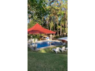 Pool with gazebo bar, BBQ and sun loungers surrounded by spacious yard at Santa Clara beach country house