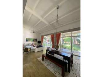 Open plan living dining space with vaulted ceilings large windows and pool views Santa Clara Panama