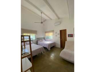 Contemporary bathroom with stone-tiled shower, tub, wooden vanity in Santa Clara beach house