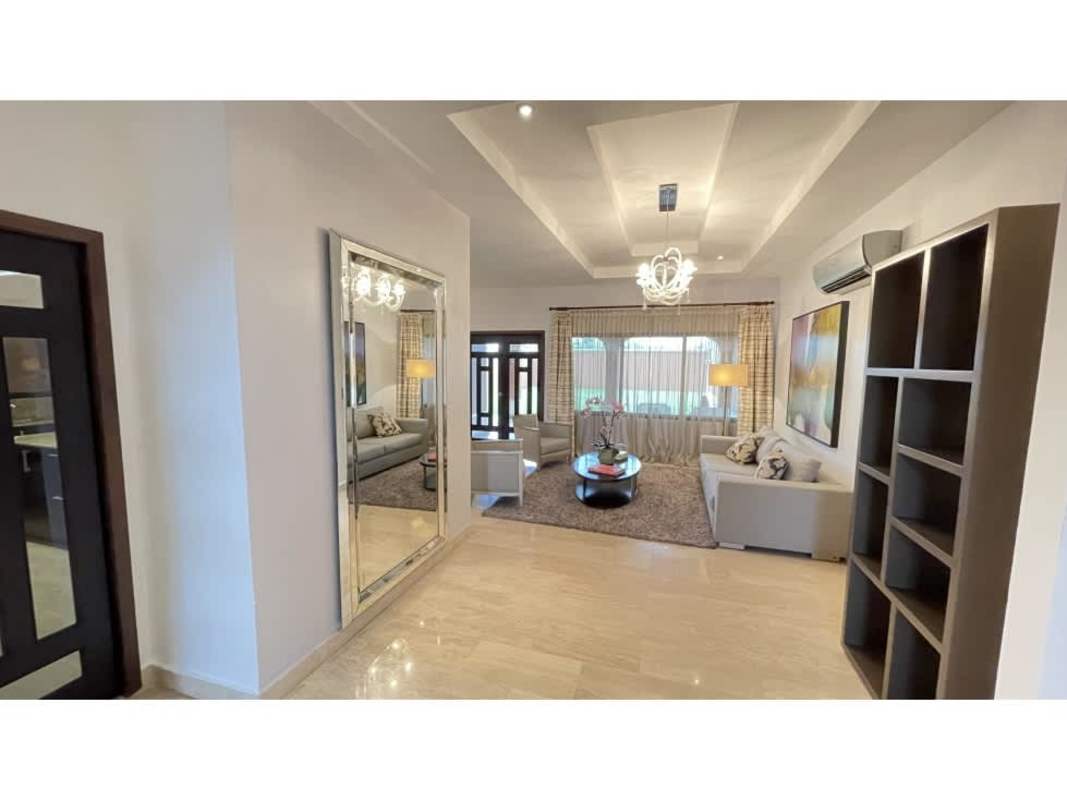 Spacious modern living room with tray ceiling, chandelier and neutral tones in Sunset Coast Costa Sur