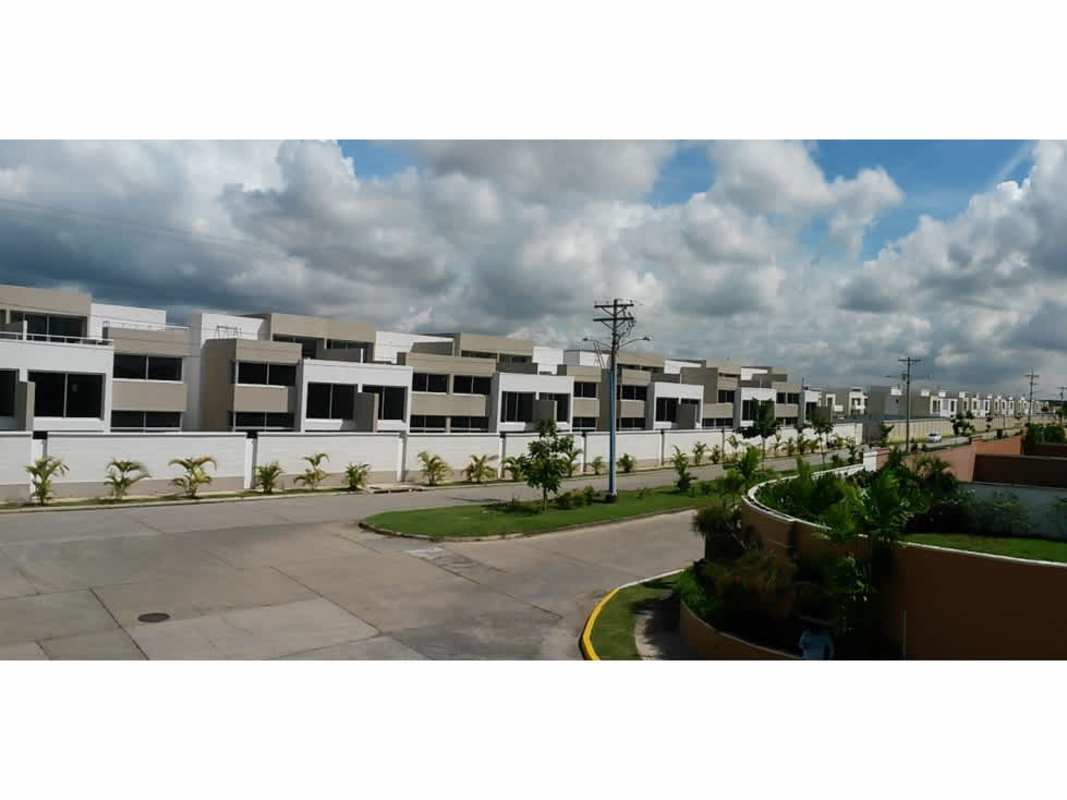 Modern row of townhomes with balconies and palm landscaping Costa Sur Village neighborhood