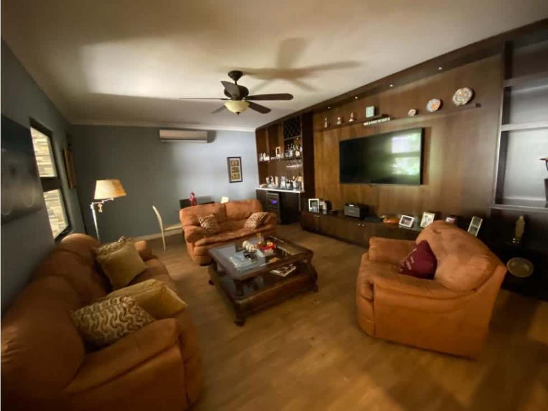 Contemporary living room with TV wall, sofas, ceiling fan Palmeras del Este Costa del Este