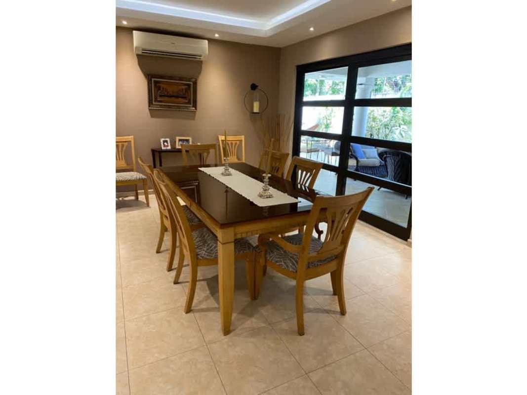 Modern dining area with wooden table, sliding glass doors to garden Palmeras del Este Costa del Este