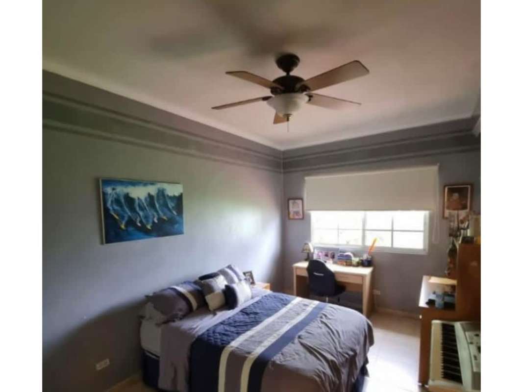 Bedroom with gray walls, upright piano, bed, ceiling fan, window Palmeras del Este Panama