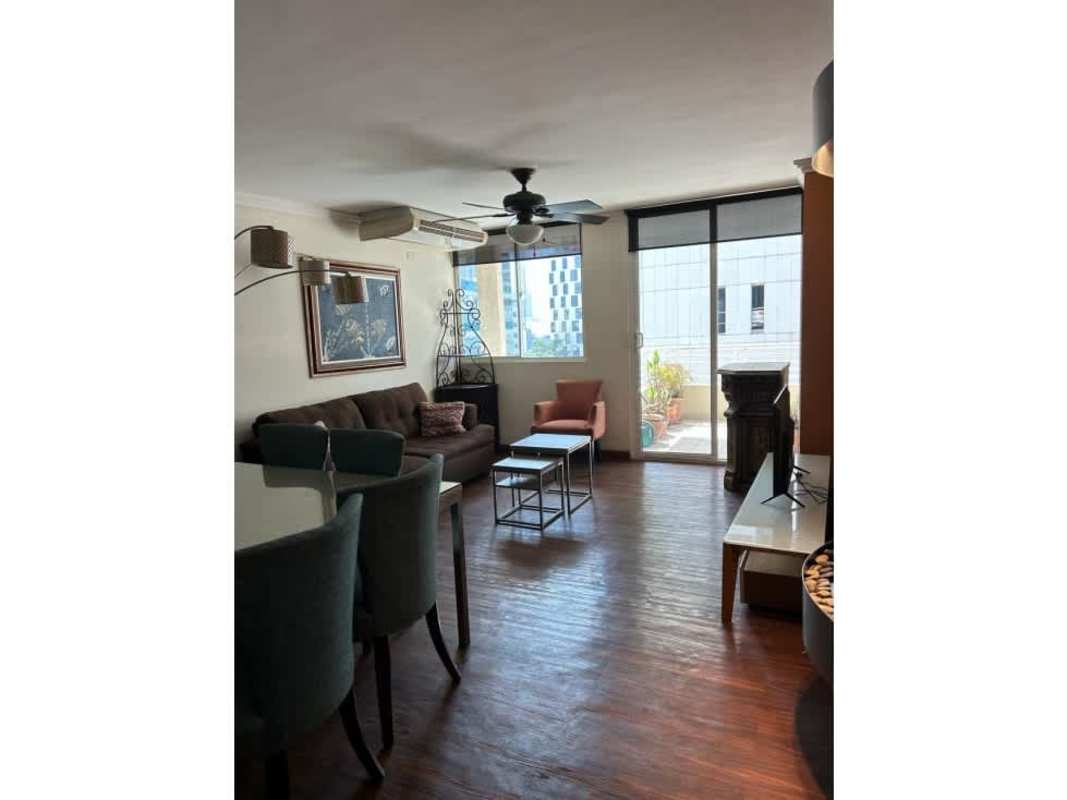 Spacious master bedroom with wood flooring and large window overlooking Obarrio skyline