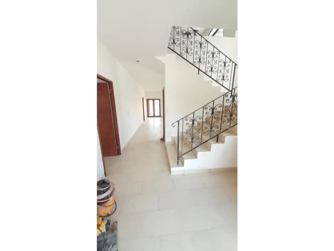 Bright hallway featuring wrought iron staircase and tiled floors in El Doral Costa Sur Panama