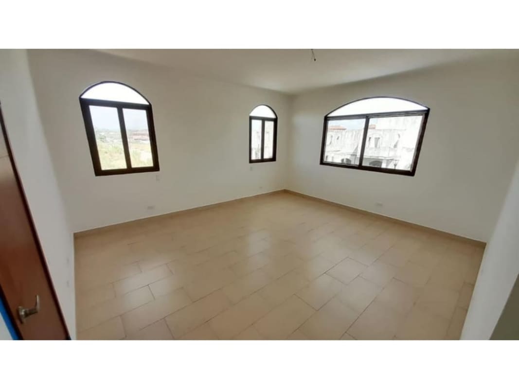 Bright empty bedroom with arched window and beige tiles in El Doral Costa Sur Panama