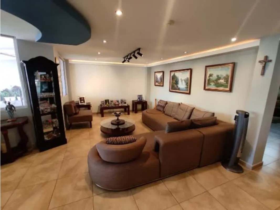 Large open living room with sectional sofa, recessed lights, art in Villa de las Fuentes Betania Panama