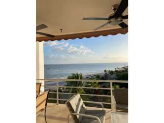 Bedroom with green bedding and large windows showing Pacific Ocean and palm trees PH Playa Blanca Río Hato Panama