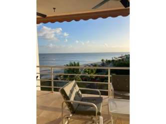 Bright living room with beige sofas, teal accents, and large windows PH Playa Blanca Rio Hato Panama