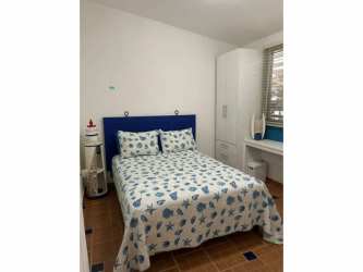 Bright living room with tile floors, sectional sofa and large garden window in Costa Grande Gorgona Panama