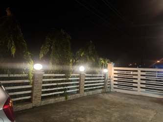 Night exterior view of secured parking entrance at Veracruz apartment complex in Arraiján.