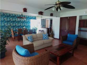 Open plan living and dining with tropical accent wall ceiling fan sofa chairs Costa Blanca Río Hato Panama