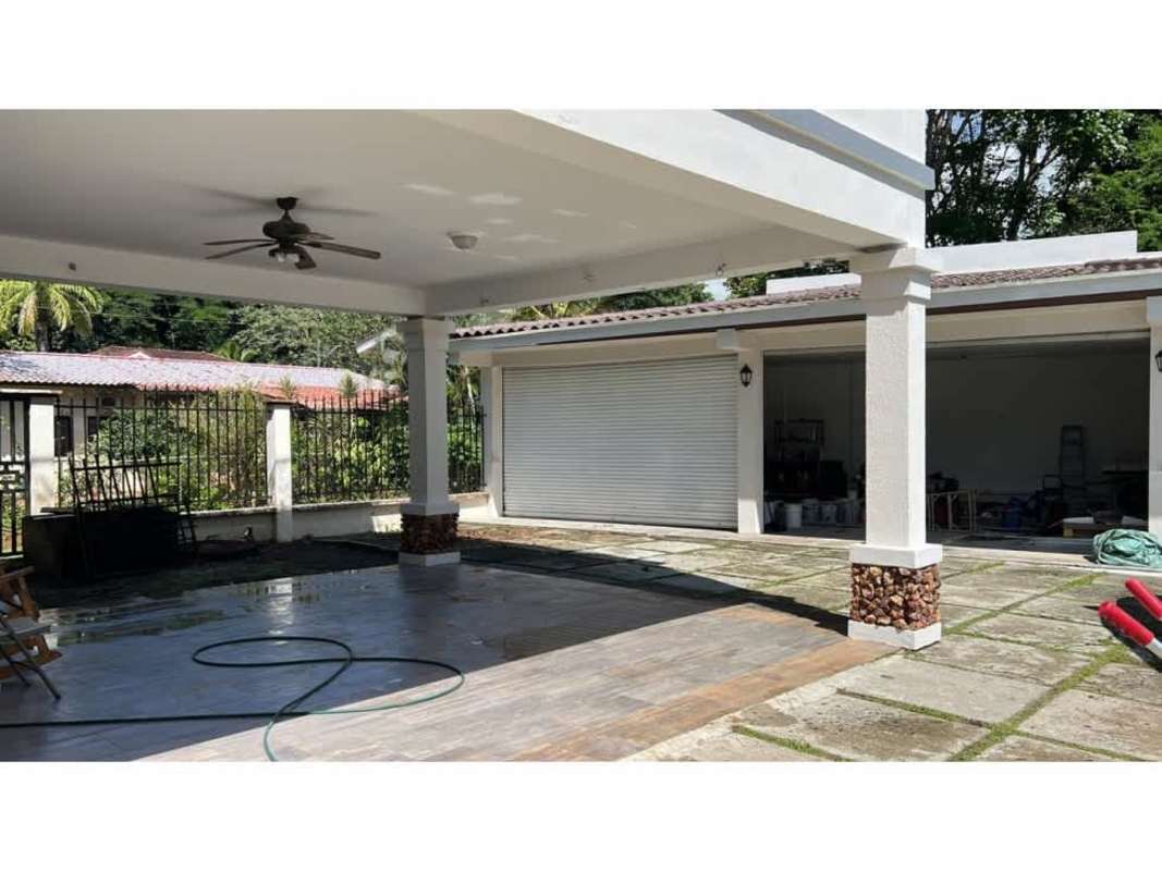 Two-story Mediterranean style house with arched windows and landscaped garden in Ancon Panama