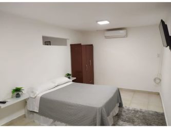 Spacious kitchen equipped with wood cabinetry, appliances inside main house Margarita Colon Panama