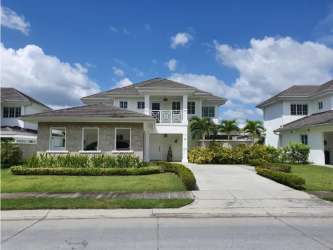 Exterior two-story beach house with balcony, manicured lawn, in Bijao Beach Resort Panama