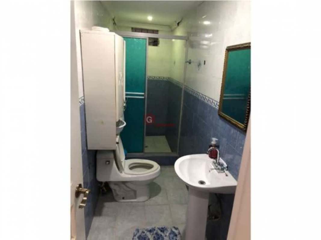 Green garden with trees, paved parking area, orange exterior walls at Villa Nueva Las Cumbres