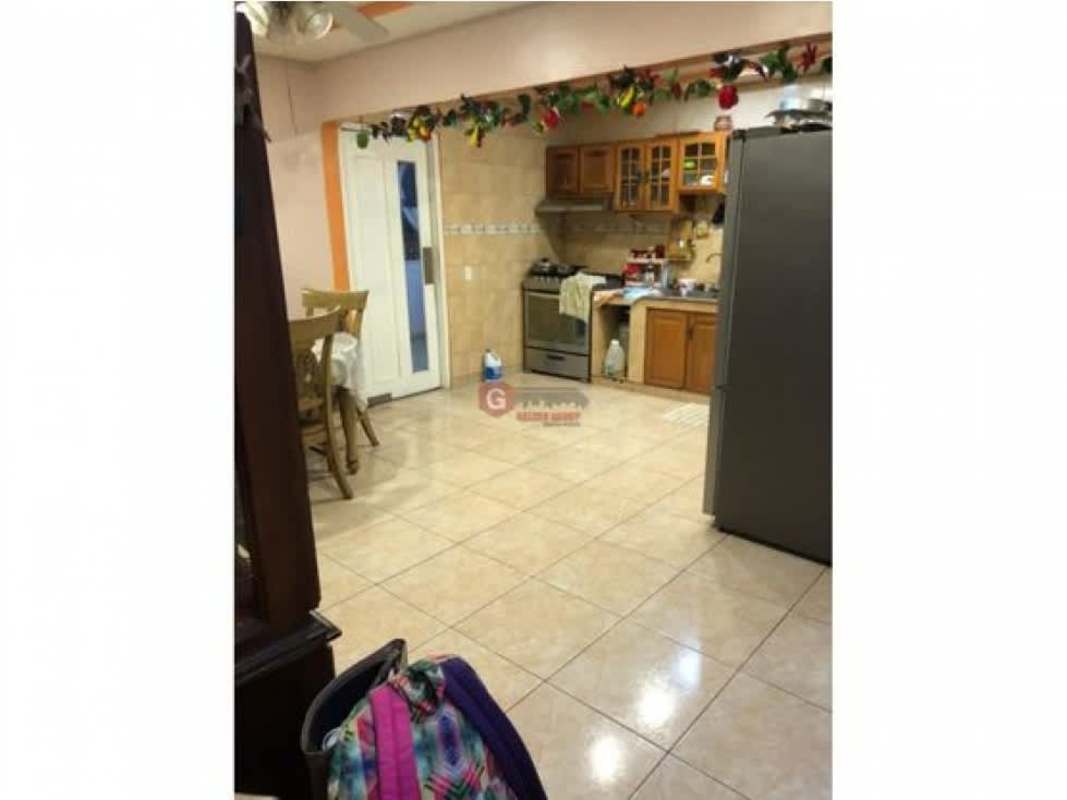 Kitchen with wood cabinets, refrigerator, dining table in Villa Nueva Las Cumbres house