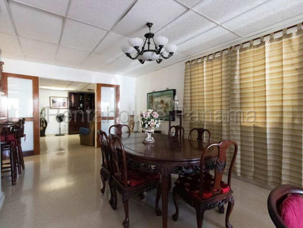 Traditional dining room with chandelier and large window in Villa Lucre Panama