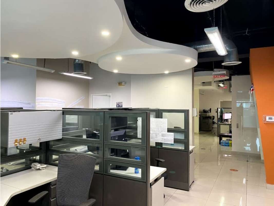 Open office with multiple cubicles, glass partitions, and window city view Panama City