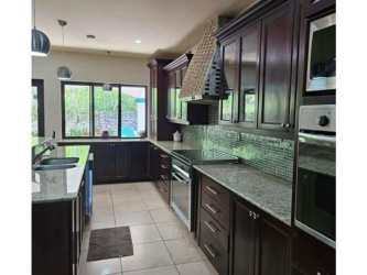Open plan dining living with vaulted beams checkered tiles chandelier Valle Escondido Boquete home