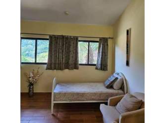 Bedroom with large windows floral curtains wood flooring garden views in Valle Escondido luxury home