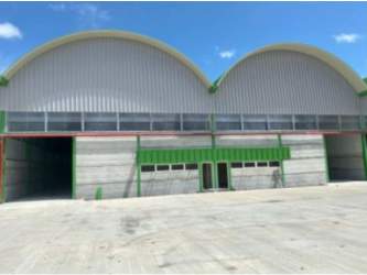 Spacious outdoor parking and arched roof industrial warehouse facade with loading bays Villa Carmen Panama