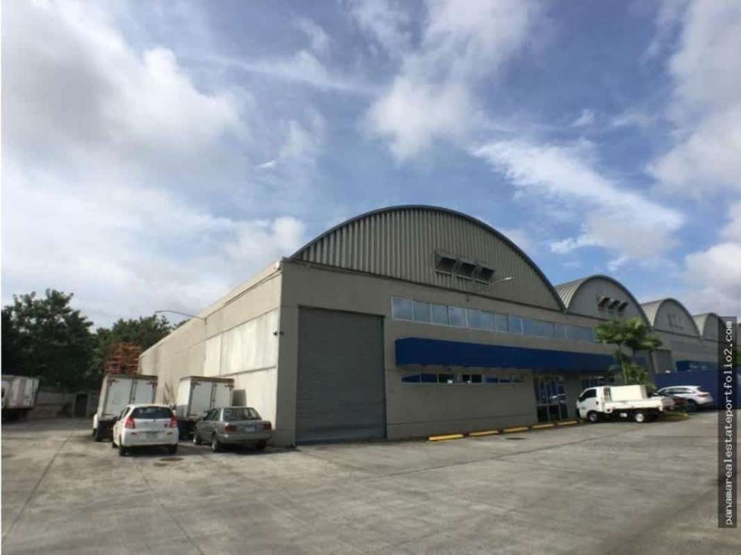 Warehouse complex with multiple loading bays parking spaces and curved metal roofs at Ofidepósitos Tocumen II Panama