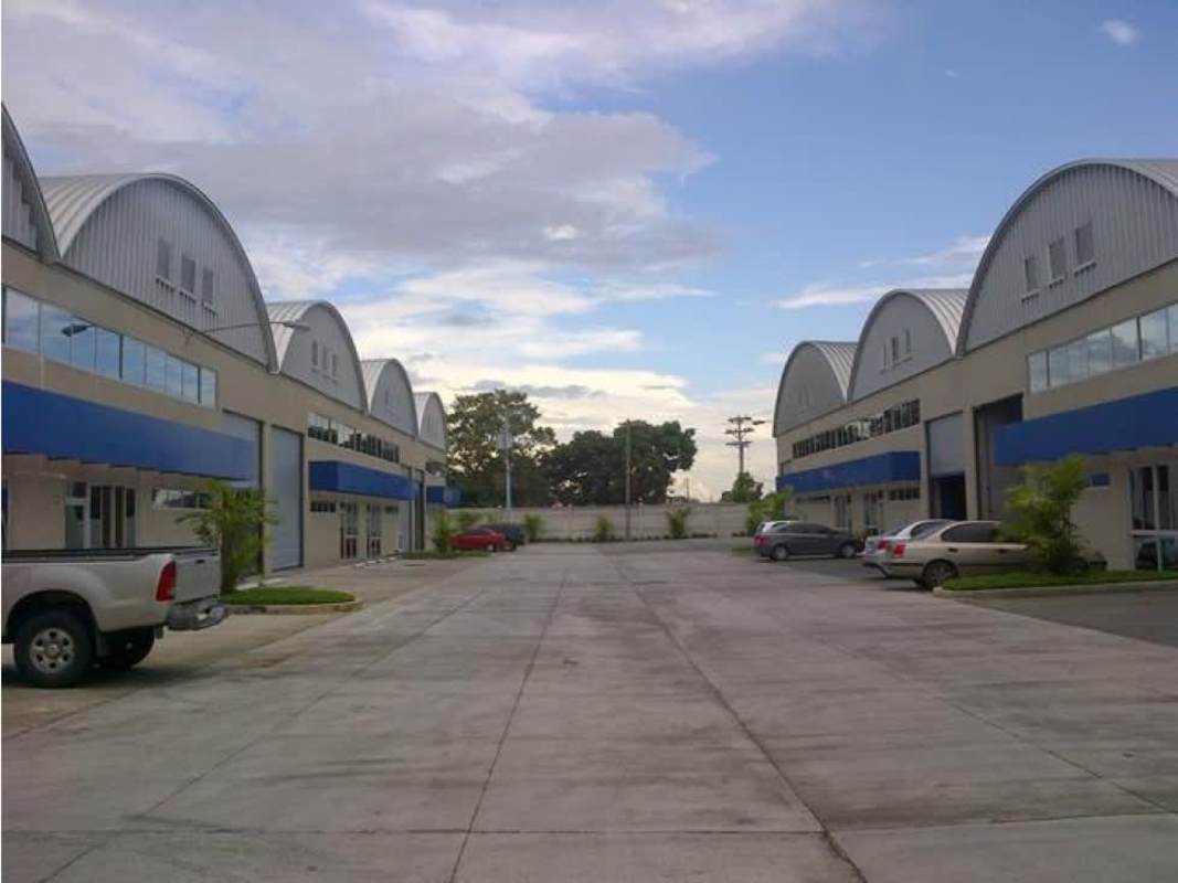 Modern industrial warehouses with blue and gray accents parking space and curved metal roofs in Tocumen II Panama City
