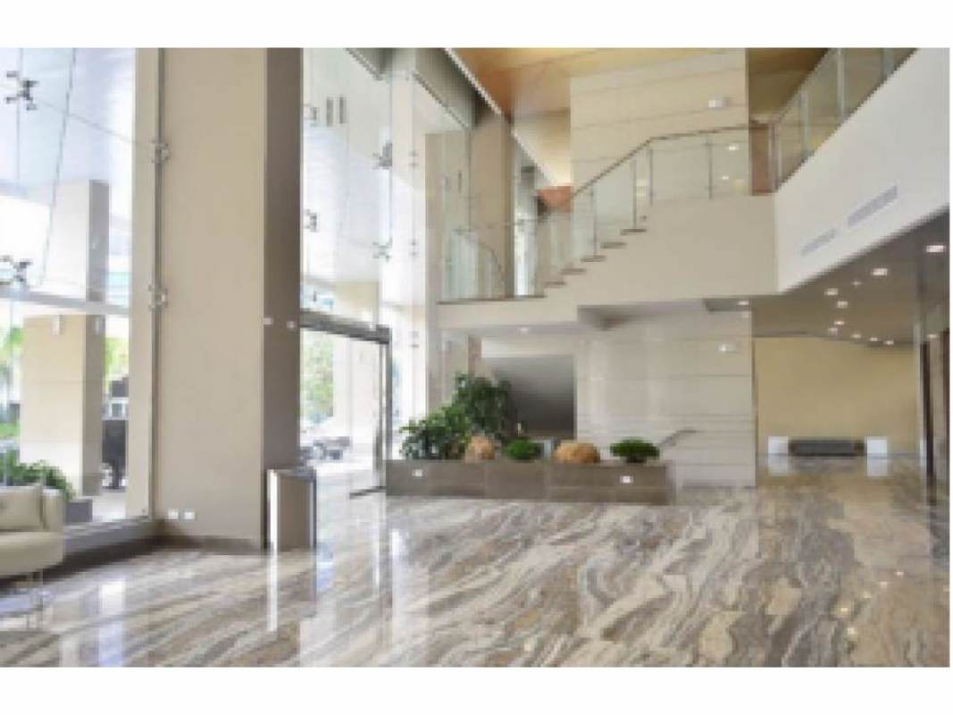 Double-height marble lobby with modern lighting and glass staircase in Costa del Este office building