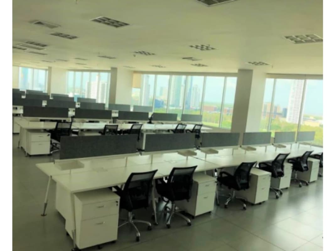 Open plan office area with multiple cubicles and floor-to-ceiling windows showing city view, Plaza del Este Panama