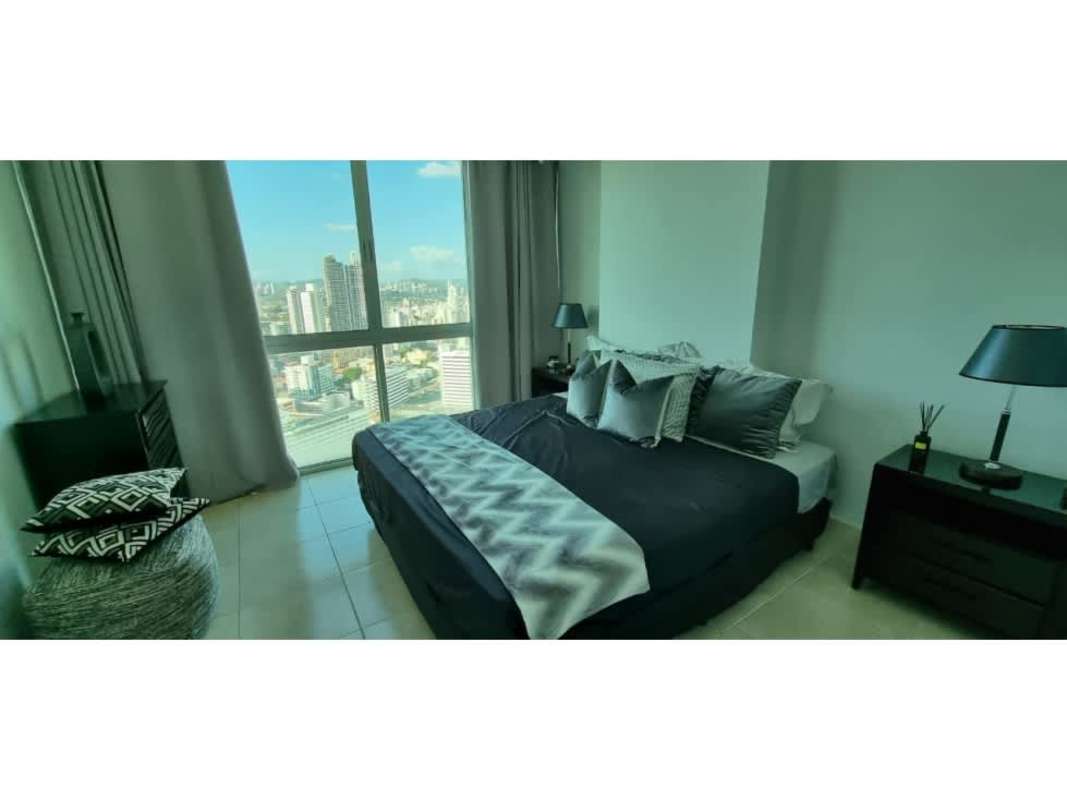 Bedroom with panoramic window city view, grey accents, modern furnishings PH The Seawaves Panama.