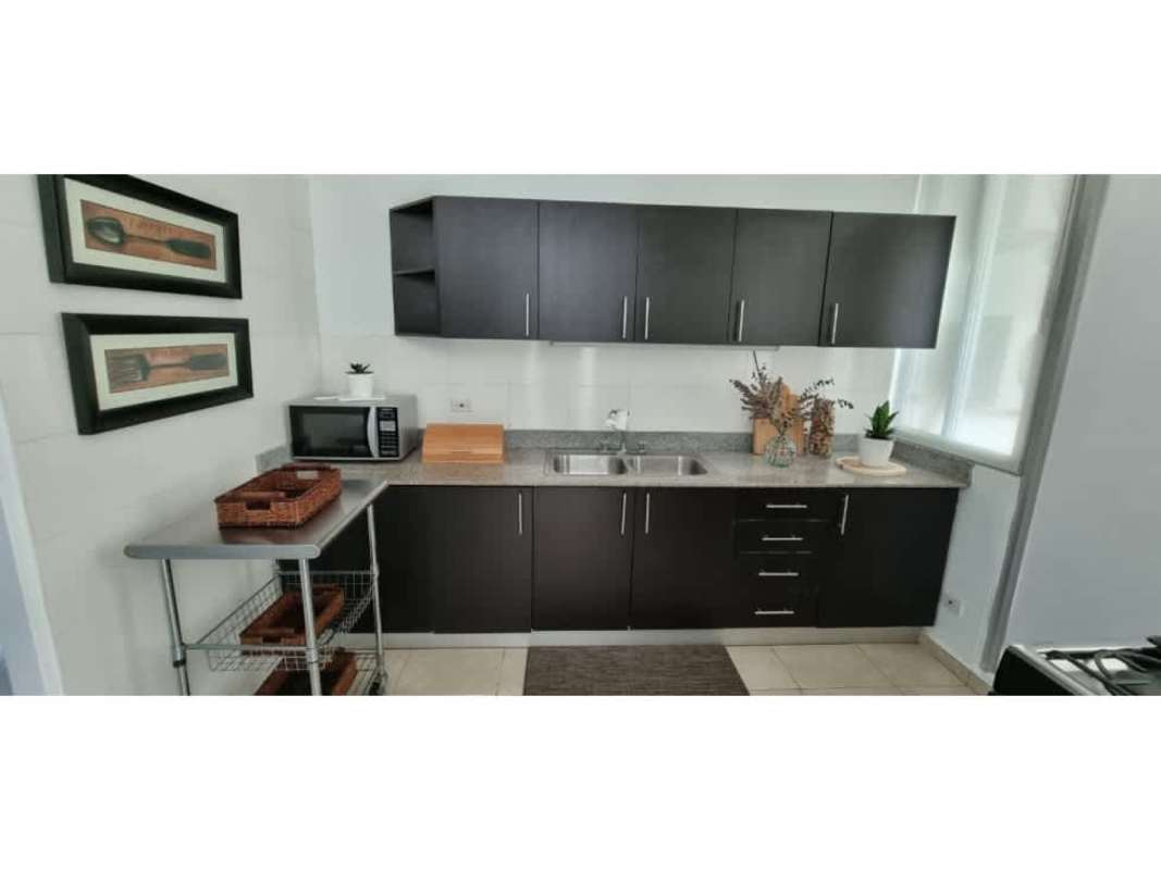 Kitchen with granite countertop, dark cabinets, window with natural light PH The Seawaves Panama City.