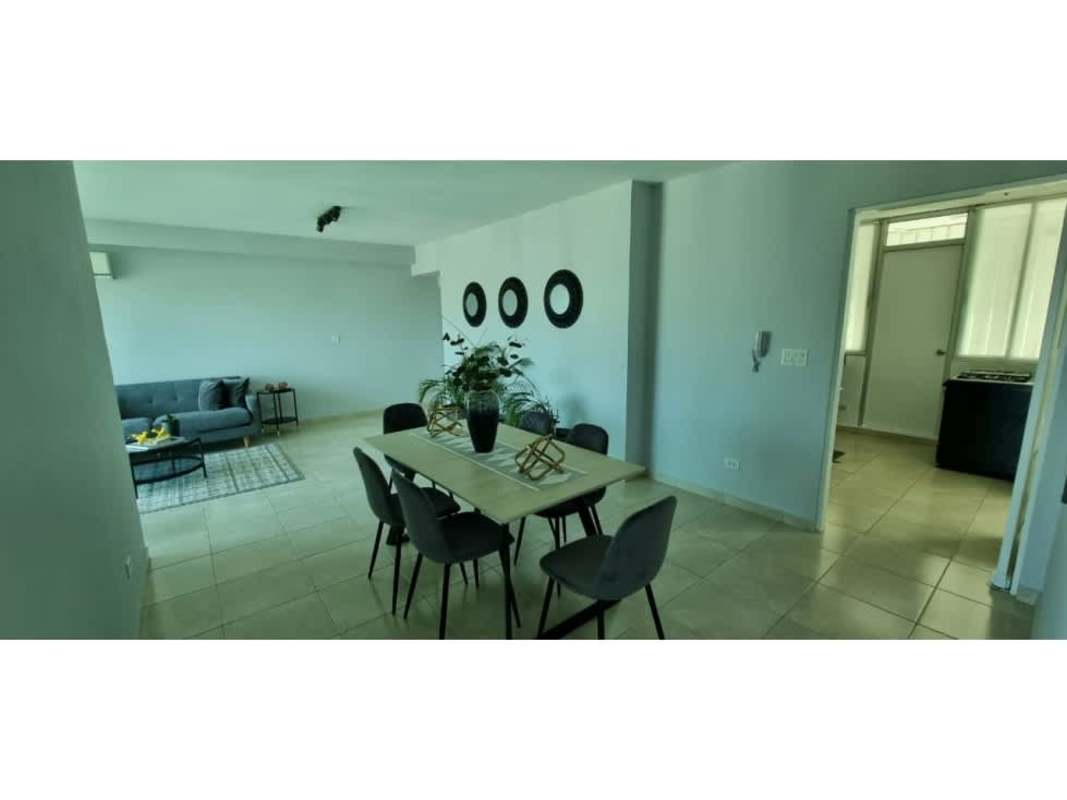 Open living and dining room with city skyline backdrop PH The Seawaves condo Panama City.