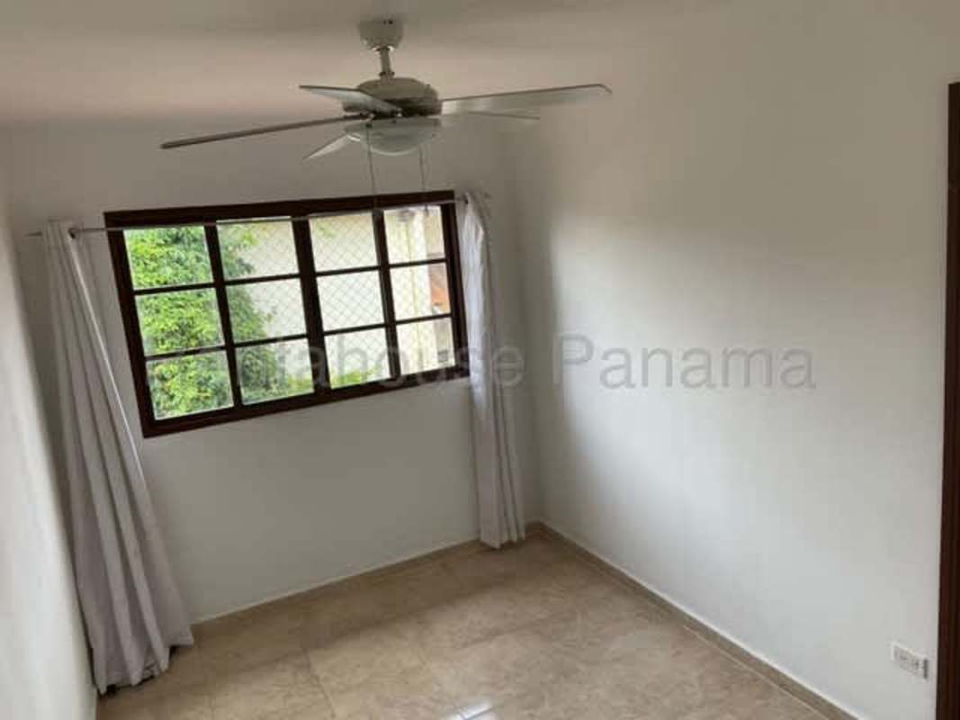 Living area with large windows, tiled floors and ceiling fan of Las Cumbres house for sale
