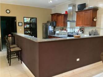 Open kitchen with granite countertops and wooden cabinetry in Maria Chiquita beach property