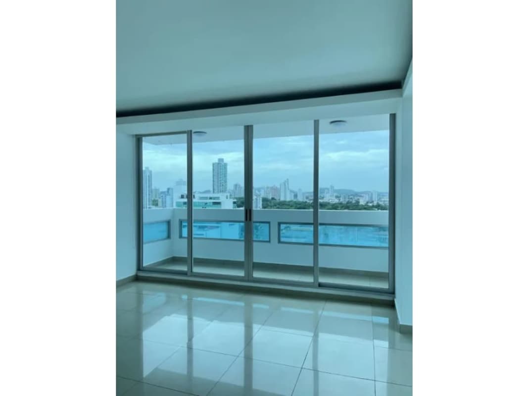 Living room with sliding glass balcony doors offering city skyline view at The View Coco del Mar