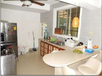 Kitchen area with breakfast bar, ceramic tiles and appliances in Howard house Panama