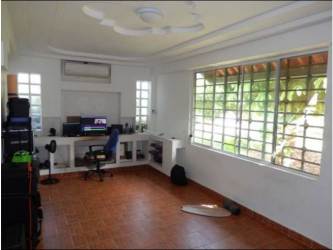 Home office with built-in desk, large windows, ceramic floors in Howard house Panama