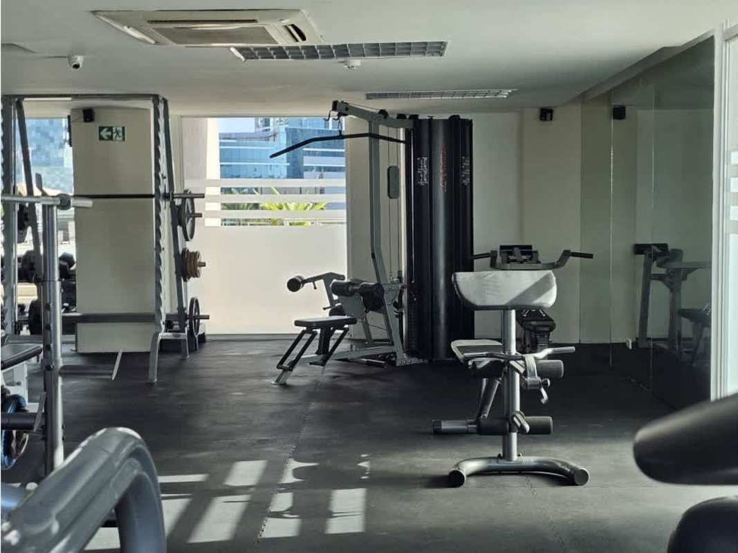 Outdoor covered lounge patio with string lights and city skyline at PH Sevilla Costa del Este