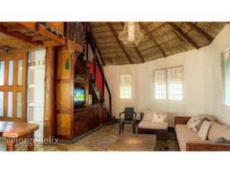 Open concept living room with loft and thatched roof in Punta Chame tropical beach villa for sale
