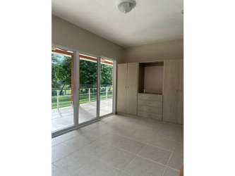 Spacious kitchen with light wood cabinets and black countertops in Villas de La Colina beach home
