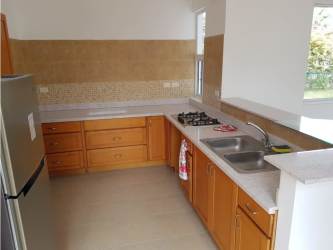 Kitchen with L-shaped counter, wooden cabinets, stainless sink in beach house Panama