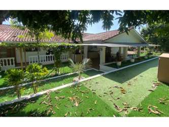 Mediterranean style house with red tile roof, landscaped garden, and wide patio in Howard Panama