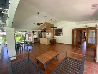 Covered outdoor terrace with dining setup and backyard view in Howard Panama home