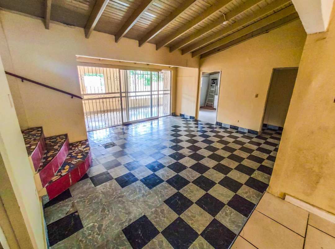 Living room with porcelain floors, high ceiling and exposed wooden beams in Betania home sale Panama