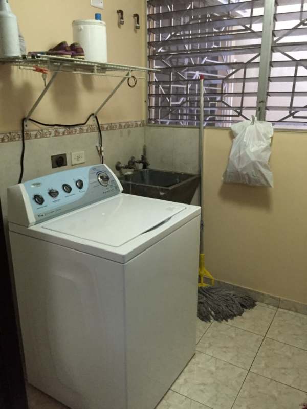 Bathroom with beige ceramic tile walk-in shower sink toilet mirror PH Betania Panama