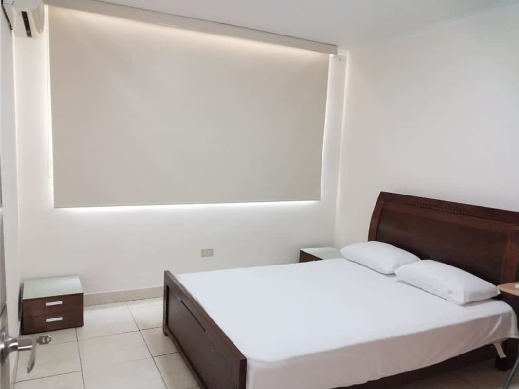 Modern bedroom with tiled floors, AC and large window cityscape view in Sunrise Tower Obarrio Panama for sale