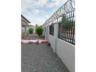 Covered front porch entrance with garden in Buena Vista Colón single family home Panama for sale.