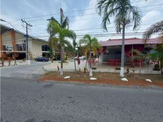 Street view of Plaza Coronado with palm trees, outdoor dining areas and commercial storefronts Panama